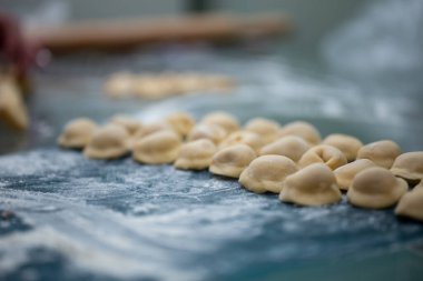 Un masasının üzerinde makarna ravioli yaptım. Yakın plan pişirilmiş hamur köftesi..