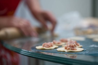 Kadın elleri ev yapımı hamur köftelerini yakın plan yapar..