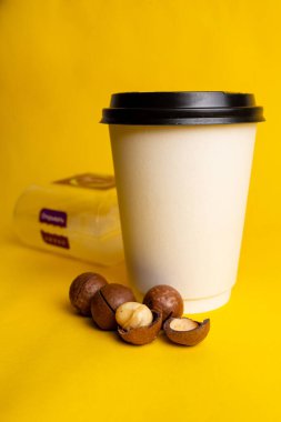 Sarı arka planda fındıklı bir bardak kahve..