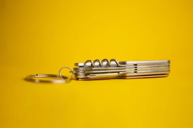 Sarı arka planda çok fonksiyonlu metal bıçak.