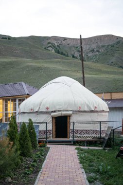 Dağların arka planında bulunan ulusal yurt.