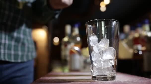 Barmanské ruce nalijí modrý sirup do sklenice s ledem — Stock video