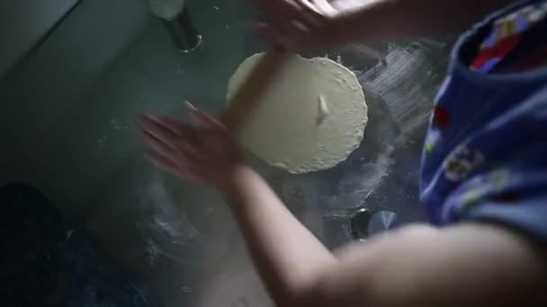 Une femme roule la pâte sur la table pour les boulettes vue du dessus — Video