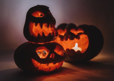 Karanlıkta Cadılar Bayramı için oyulmuş üç balkabağı..