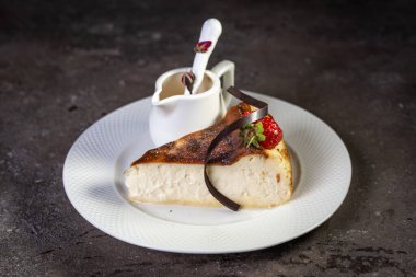 Beyaz tabakta peynirli çilekli kek.