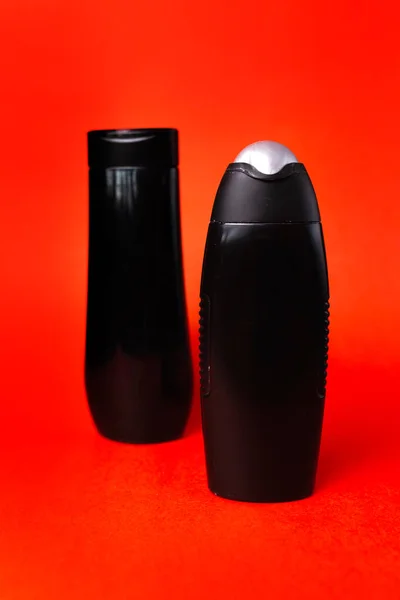 Két Fekete Műanyag Palack Piros Alapon — Stock Fotó