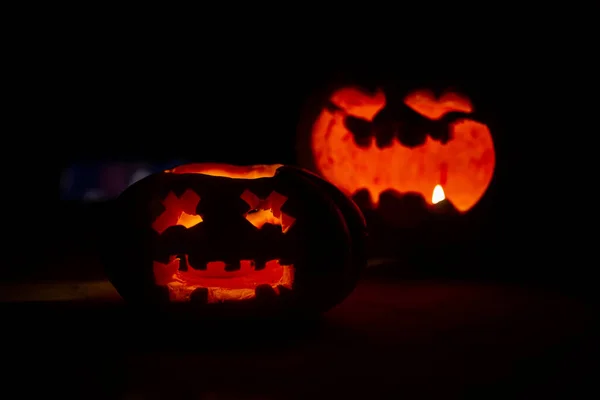 ハロウィンのために暗闇の中にろうそくのついたカボチャを2つ彫り — ストック写真