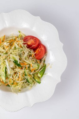 Lahana, havuç ve domatesli taze salata manzarası. Hafiflik ve tazelik yakalar - sağlıklı beslenme menüleri ve yemek blogları için mükemmeldir..