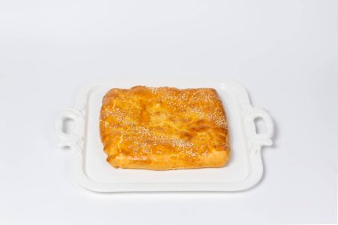 Golden sesame bread on white plate. Highlights the warmth of homemade baking - perfect for food blogs and cookbooks.