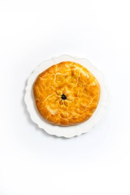 Beyaz bir yüzey üzerinde altın kahverengi kabuklu iştah açıcı bir turtanın üst görüntüsü.