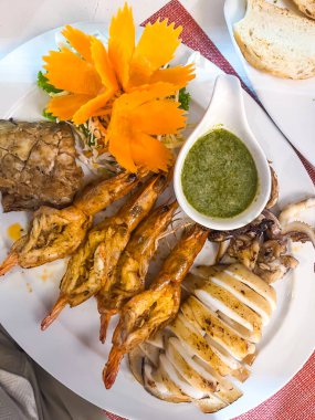 Izgara karides ve yeşil soslu balık. Restorandaki deniz ürünleri. Yüksek kalite fotoğraf