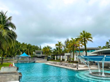 Yüzme havuzları ve palmiye ağaçları olan bir dinlenme alanı..