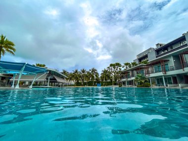 Yüzme havuzları ve palmiye ağaçları olan bir dinlenme alanı..