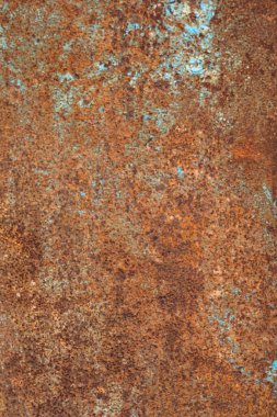 Close-up of rusty metal surface with brown and blue patches. Natural texture of aged metal.