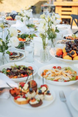 Ilık altın saat sahnesinde yemyeşil çiçekler, canlı yemekler ve rafine kaplama - lüks etkinlik planlaması veya romantik yaşam tarzı görselleri için ideal.