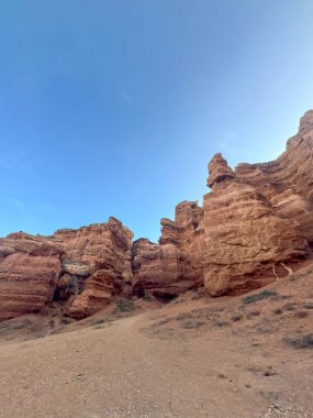 Charyn Kanyonu kaya oluşumlarının alçak açılı görüntüsü: katmanlı taş, mavi gökyüzünün altında Kazakistan 'ın vahşi doğası.