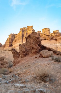 Çöldeki kaya kuleleri: engebeli doku, katmanlı uçurumlar ve berrak mavi gökyüzü.