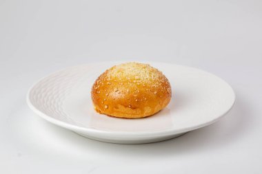 Ekmek dürümünün beyaz desenli tabakla yakın çekimi - beyaz arka planda iştah açıcı hamur işleri. 