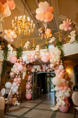 Balon kemerli ve oyuncak ayılı geniş bir salon çekimi. Çocuklar için lüks bir dekor..