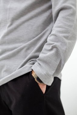 Gri tişörtlü, siyah pantolonlu bir adamın yan görüntüsü..