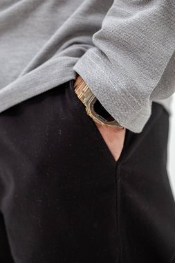 Gri t-shirt 'ün altında akıllı cımbızlı siyah pantolonlu adamların yakın çekimi.