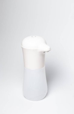 Beyaz arkaplanda beyaz otomatik sabun dağıtıcısını kapat.