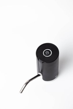 Beyaz zemin üzerinde kıvrımlı metal püskürtüsü olan siyah dokunuşsuz otomatik sabun dağıtıcısına yakın çekim.