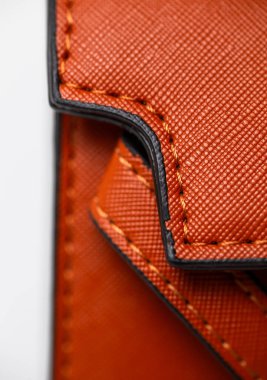 Turuncu dikişli, siyah süslemeli zarif kahverengi deri cüzdan moda aksesuarları ve lüks ürün fotoğrafçılığı için ideal..