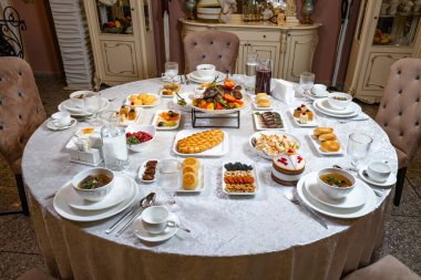 Şatafatlı, yuvarlak sofra, gurme yemekler, hamur işleri ve klasik iç dekorasyonda zarif gümüş eşyalar..