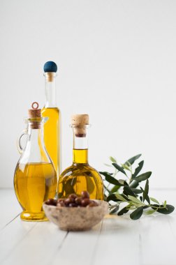 Üç küçük şişe zeytinyağı ve zeytin salamura