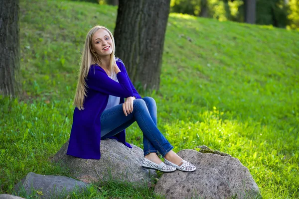 Portrait extérieur d'une belle fille blonde dans le parc assis — Photo