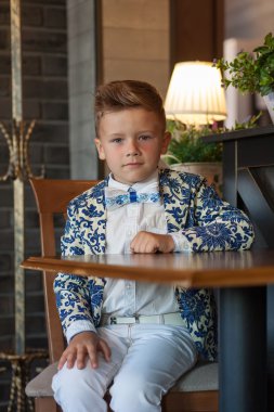 Restoranda oturan sevimli küçük çocuk