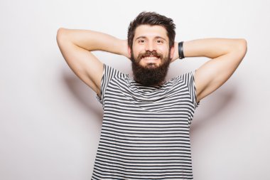 Beyaz arka planda dururken sakallı ve el ele tutuşan ve gülümseyen yakışıklı genç adam