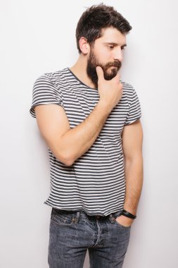 Yan Portre beyaz arka plan karşı dururken sakallı gülümseyen el ile yakışıklı genç adam