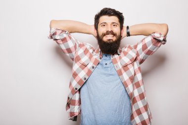 Beyaz arka planda dururken sakallı ve el ele tutuşan ve gülümseyen yakışıklı genç adam