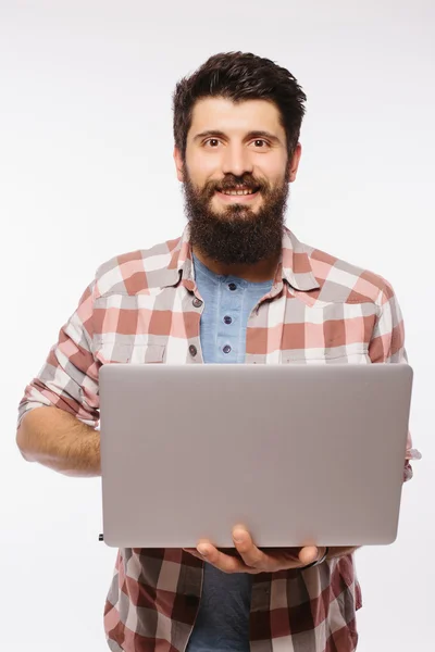 Portrait de bel homme barbu hipster avec ordinateur portable dans les mains sur fond blanc — Photo