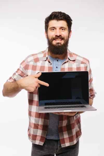 Retrato de hombre barbudo hipster guapo con portátil. Barbudo hombre demostrando portátil contra fondo blanco —  Fotos de Stock