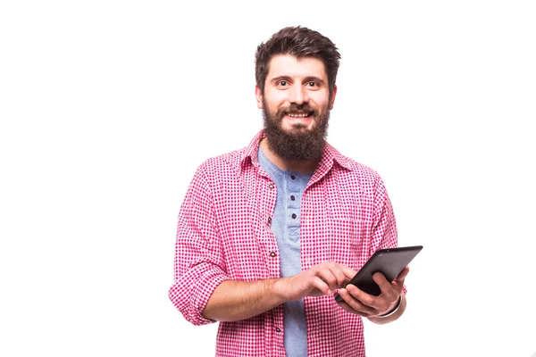 Tablet bilgisayar kullanarak sakallı bir hipster adam portresi ve beyaz bir arka plan üzerinde izole kamera bakmak — Stok fotoğraf