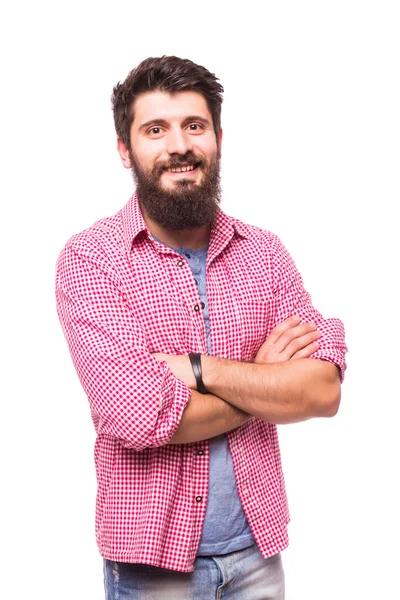 Beyaz arka plan aleyhine dururken çapraz elleri ile sakallı yakışıklı genç adam