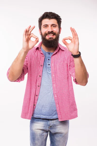 Retrato de un hombre hipster feliz con barba mostrando signo aceptable con los dedos sobre fondo blanco — Foto de Stock