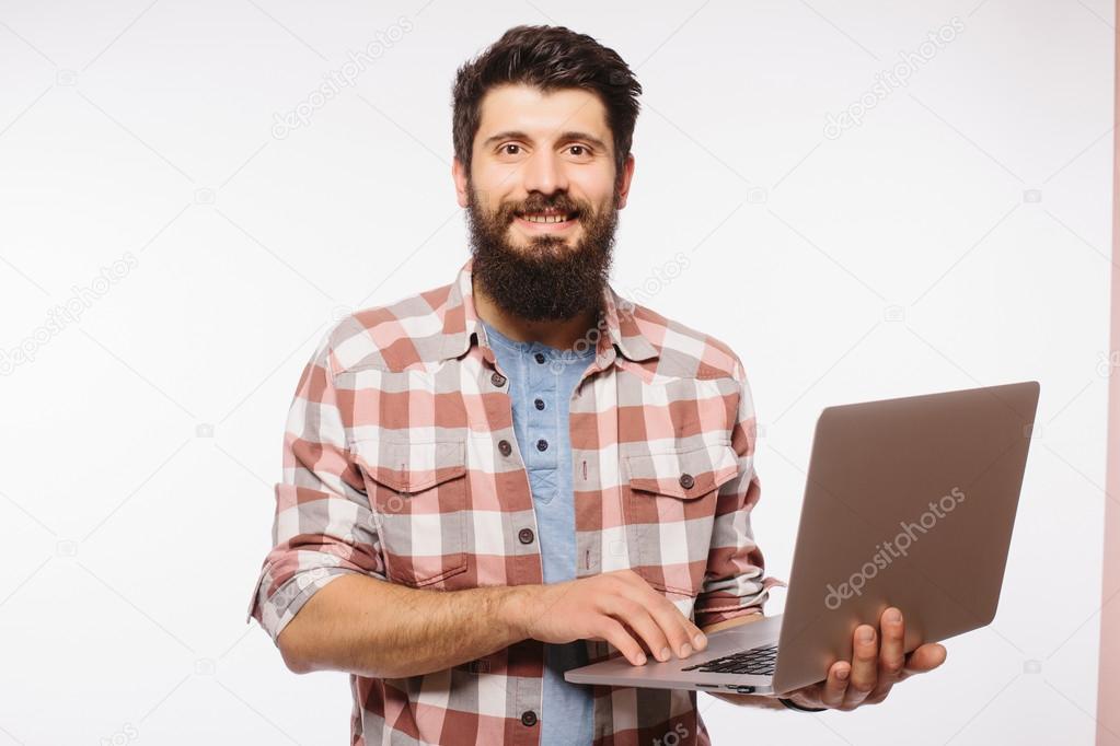 Portrait of handsome hipster bearded man with laptop  in hands  against white background