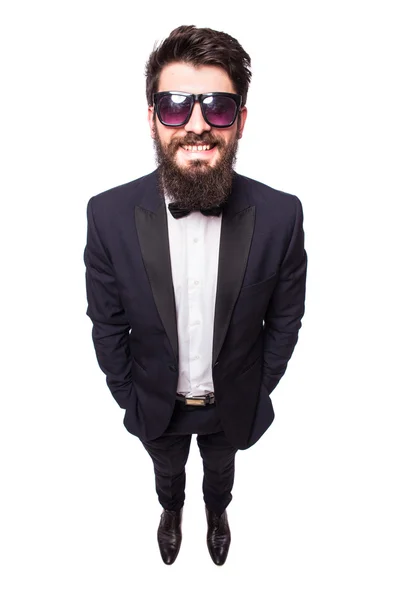 Joven guapo en traje negro y gafas de sol haciendo selfie y sonriendo mientras está de pie sobre fondo gris — Foto de Stock