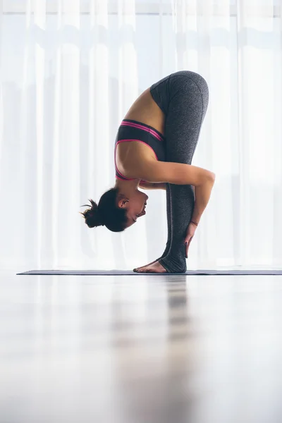 Vackra yoga kvinnan praxis i en utbildning hall bakgrund. Yoga-konceptet. — Stockfoto