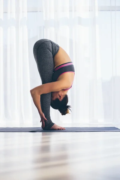 Vackra yoga kvinnan praxis i en utbildning hall bakgrund. Yoga-konceptet. — Stockfoto