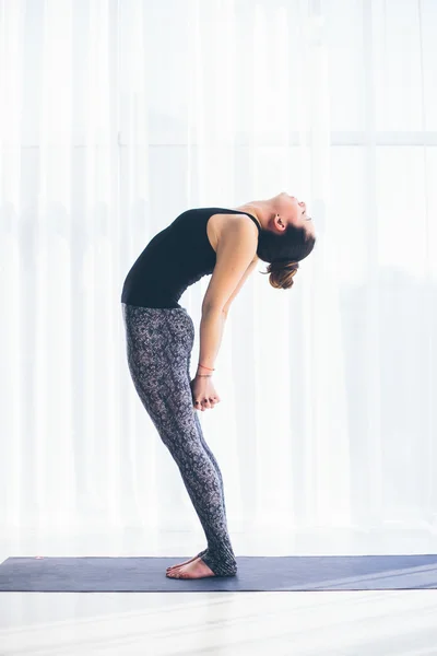 Vackra yoga kvinnan praxis i en utbildning hall bakgrund. Yoga-konceptet. — Stockfoto