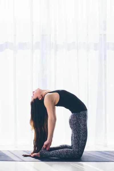 Vackra yoga kvinnan praxis i en utbildning hall bakgrund. Yoga-konceptet. — Stockfoto