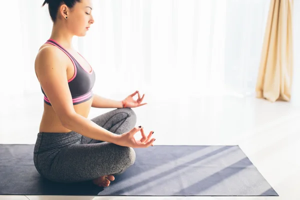 Hermosa práctica de yoga mujer en un fondo sala de entrenamiento. Concepto de yoga . —  Fotos de Stock