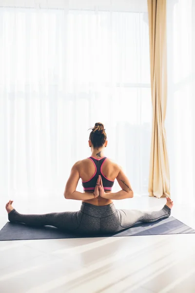 Güzel yoga kadın pratik bir eğitim salonu arka planda. Yoga kavramı. — Stok fotoğraf
