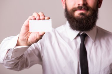 Holding ve boş kartı işaret eden sakallı adam