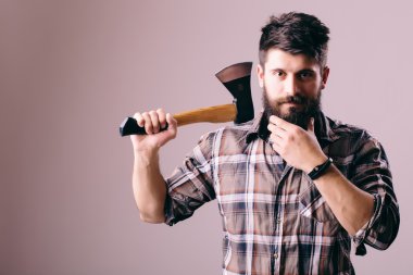 Tıraş balta ile. Kendine güvenen genç sakallı adam büyük bir balta taşıyan